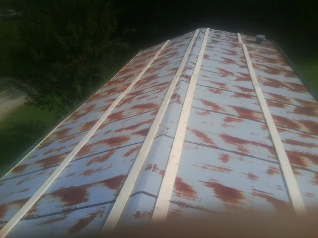 Rusted metal roof panels with new wood purlins before replacement — Storm Damage Roof Repair in Attalla by Roofing Brothers