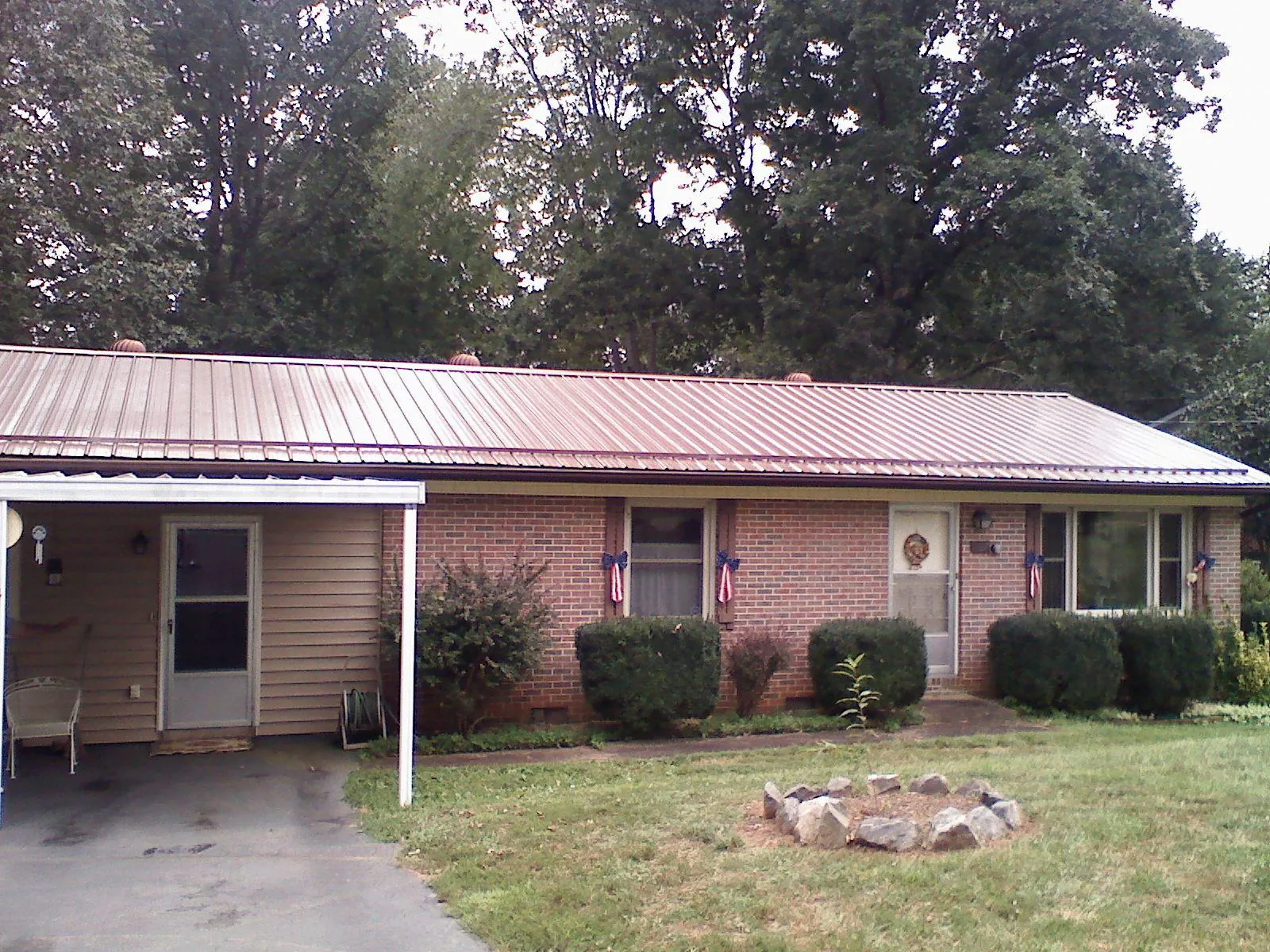 Bronze metal roof and carport on a brick ranch home — Roof Repair work by our crew in Attalla